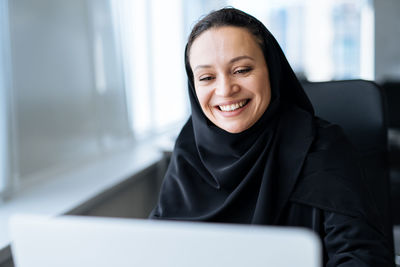 Portrait of young woman using laptop at home