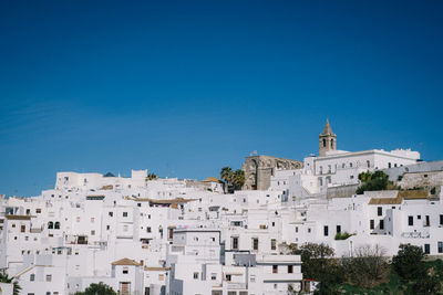 Low angle view of residential district against clear blue sky