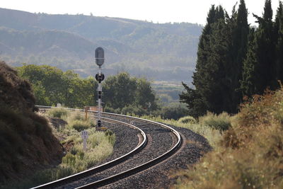 Railroad tracks by mountains against sky