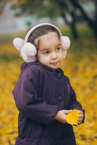 Close-up of girl standing on field during autumn