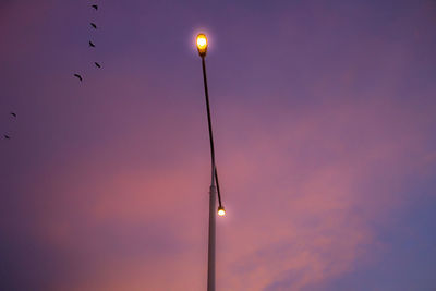 Low angle view of illuminated street light against sky at night