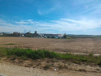 Agricultural field against cloudy sky
