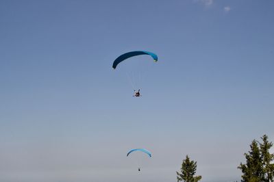 Low angle view of person paragliding against sky