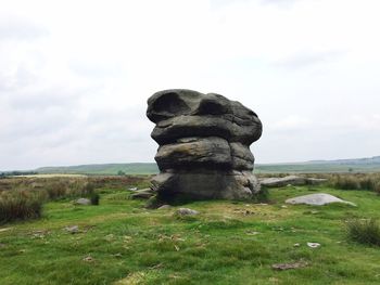 Statue on field against sky