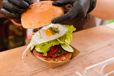 Cropped image of vendor preparing hamburger on table at market