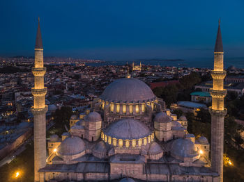 Illuminated buildings in city against sky