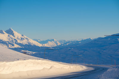 Scenic view of snowcapped mountains against clear blue sky