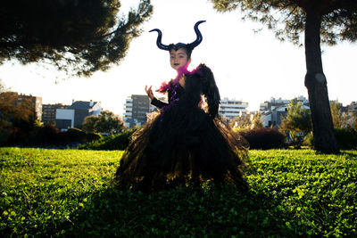 Girl with maleficent costume playing in the woods