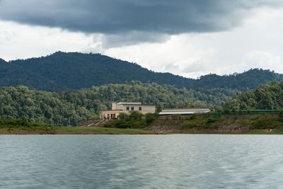 Scenic view of lake by buildings against sky