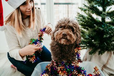 Woman with dog sitting at home