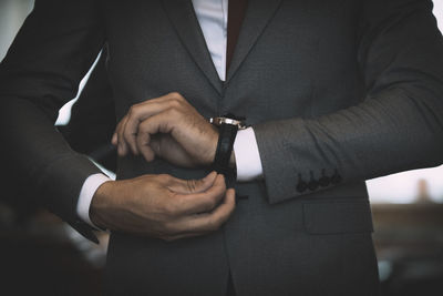 Midsection of businessman wearing wristwatch