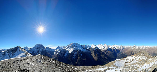 Scenic view of snowcapped mountains against clear blue sky