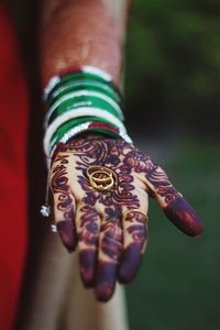 Close-up of bride hand with henna tattoo holding rings