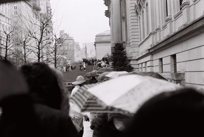 Midsection of woman with umbrella in city