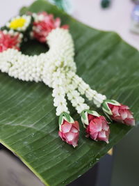 Close-up of floral garland on banana leaf