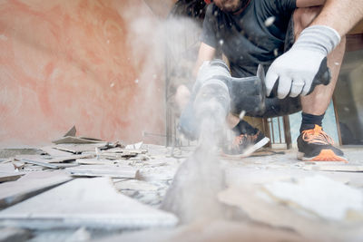 Midsection of man working on metal