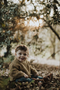 Portrait of cute girl sitting on tree