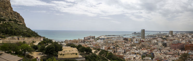 High angle view of townscape by sea against sky