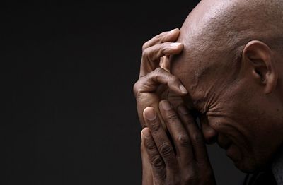 Close-up of senior man against black background