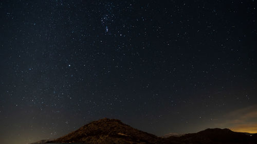 Low angle view of mountain against star field