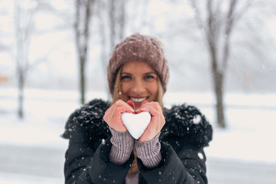 Portrait of woman holding ice cream in winter