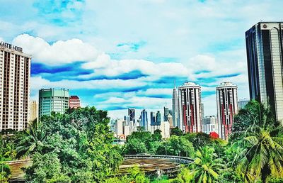 Low angle view of skyscrapers against cloudy sky