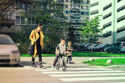 Boys riding bicycle on street in city