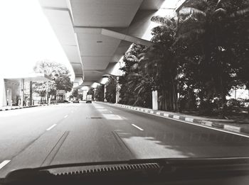 Empty road with trees in background