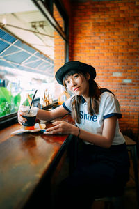 Portrait of young woman sitting in restaurant