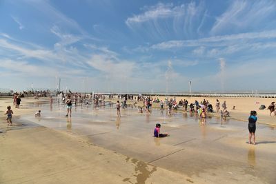 People at beach against sky