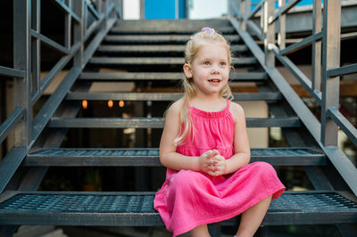 Portrait of young woman standing on staircase