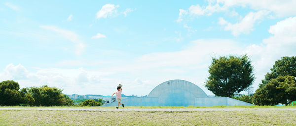 Woman standing on field against sky