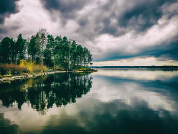 Scenic view of calm lake against cloudy sky