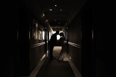 Bride and groom kissing in corridor