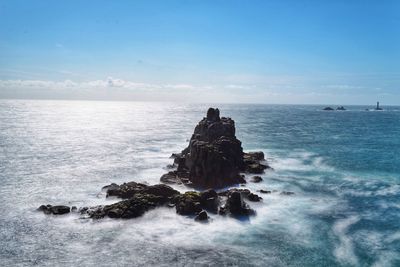 Scenic view of rocks on sea against sky