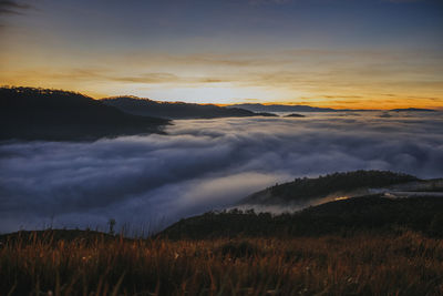 Scenic view of dramatic sky over land during sunset