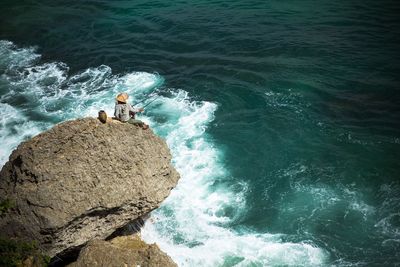 High angle view of man fishing at cliff
