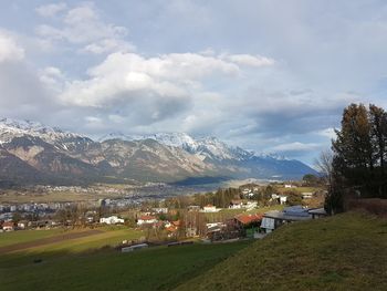 Scenic view of field and buildings against sky