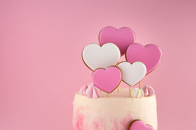 Directly above shot of christmas decorations on pink background