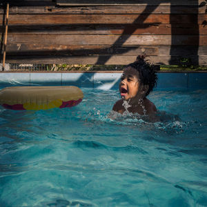 Young boy enjoying swimming in pool 