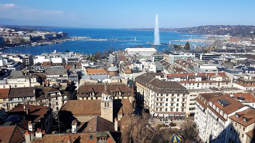 High angle view of cityscape by sea against sky