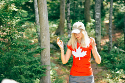 Side view of woman standing in forest