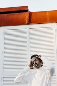 Man wearing white turtleneck holding head in hands