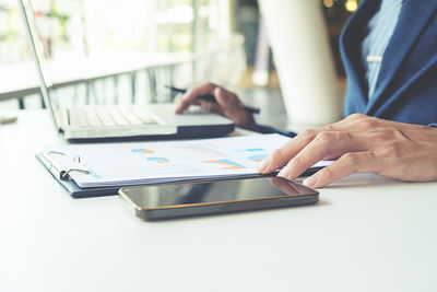 Close-up of woman using laptop on table