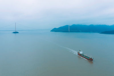 Ship sailing on sea against sky