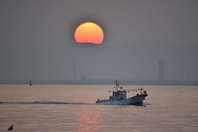 Sailboat on sea against sky during sunset