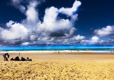 People on beach against sky