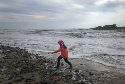 Full length of girl walking on shore at beach