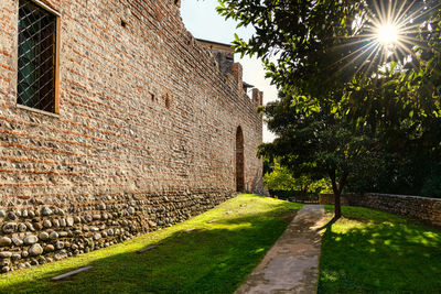 Sunlight falling on footpath by wall of building