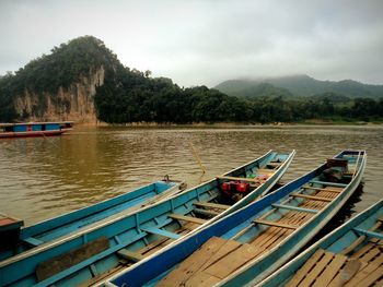 Boats moored on lake against sky